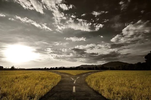 A fork in a rural road under a dramatic sky